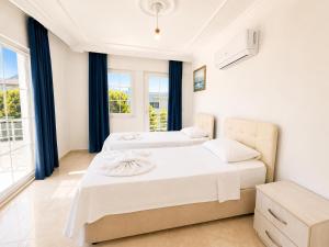 two beds in a room with two windows at Villa Fergana in Oludeniz +13 photos