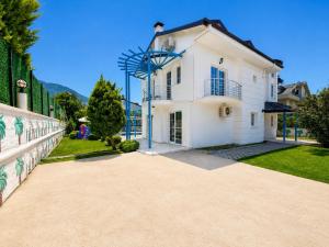 a white house with a fence and a driveway at Villa Fergana in Oludeniz