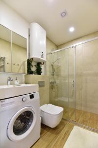 a bathroom with a washing machine and a toilet at Nerija in Juodkrantė