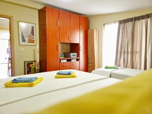 a bedroom with two beds with yellow towels on them at SUNTAN Lovely Apartment in Golem
