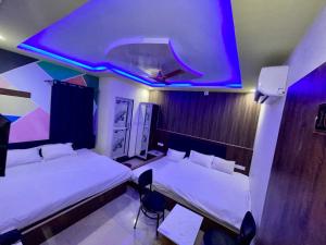 a room with two beds and a large screen at Hotel sagar inn in Ajmer