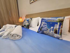 a blue bed with pillows and towels on it at Maison de Ciro in Gragnano