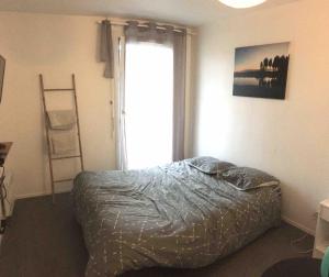 a bedroom with a bed and a window and a ladder at Studio BRITTANY in Chambéry