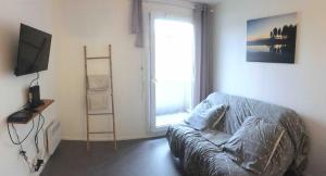 a living room with a couch and a window at Studio BRITTANY in Chambéry
