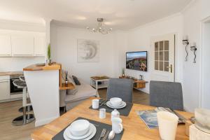 a kitchen and living room with a table and chairs at Syltliebe in Westerland