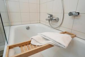 a bathroom with a bath tub with a towel at Syltliebe in Westerland +17 photos