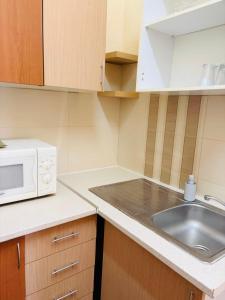a kitchen with a sink and a microwave at Casa dos Tios- Estremoz in Estremoz