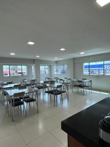 a dining room with tables and chairs and windows at Hotel 2001 in Iraí de Minas +1 photo