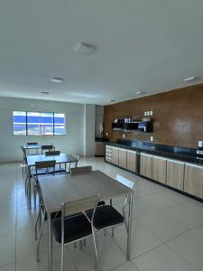a cafeteria with tables and chairs and a kitchen at Hotel 2001 in Iraí de Minas