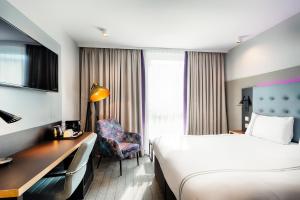 a hotel room with a bed and a desk at Premier Inn Wolfsburg City Centre in Wolfsburg