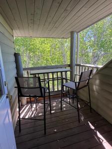 two chairs and a table on a porch at The Wandering Antler - Bragg Creek in Bragg Creek