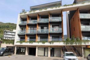 an apartment building with cars parked in a parking lot at Azure Bay Apartments in Donja Lastva