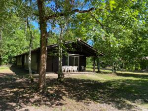a log cabin with a table and chairs in a yard at Fre&dom in Lacanau