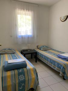 two beds in a room with a window and a table at Fre&dom in Lacanau