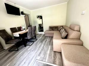 a living room with a couch and a table at Liliput Apartman in Sarkad