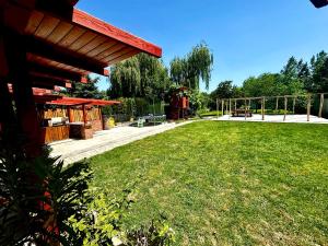 a yard with a pavilion and a grass field at Liliput Apartman in Sarkad