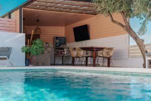 a pool with a table and chairs next to a house at B&B Casa Mijo in Daimalos