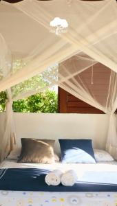 a bed with a canopy with two pillows at Villa Cajuiero Inn in Prea