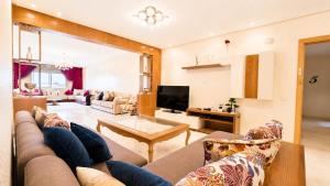 a living room with a couch and a tv at Luxury family apart parc plaza Mohammedia in Mohammedia