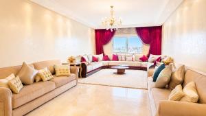 a large living room with couches and red curtains at Luxury family apart parc plaza Mohammedia in Mohammedia