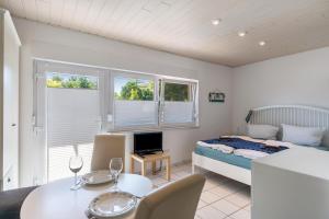 a bedroom with a bed and a desk and a table at Haus Achtern Diek - Ferienwohnungen in Wangerland