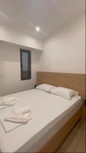 a white bed with two white pillows on it at Grey Pearl Apartments in Nea Kallikrateia +13 photos