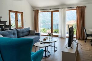 a living room with a blue couch and a tv at Hill House Orahovac in Kotor