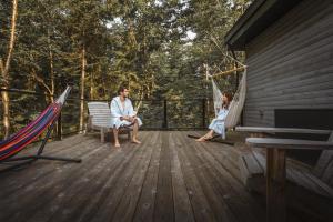 two people sitting in hammocks on a deck at Chalet la coulée douce, Expérience thermale privée in Saint Come +9 photos