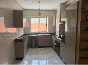a kitchen with a sink and a stove at Licht & ruim 2-slaapkamer appartement met airco & Wifi - rustig wijk Marrakesh in Marrakesh