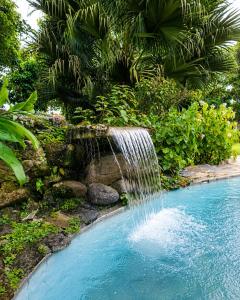 a waterfall in the middle of a swimming pool at Hotel Rincón Vallero in Valle de Anton
