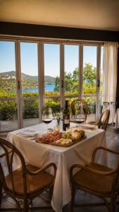 a table with a plate of food and glasses of wine at JR Resort Elba International in Capoliveri