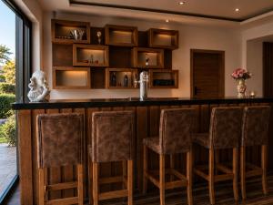 a bar in a home with brown stools at Zenith Hotel Frankfurt Airport in Kelsterbach