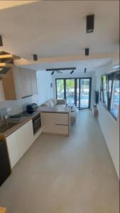 a kitchen and living room with white furniture and windows at Grey Pearl Apartments in Nea Kallikrateia