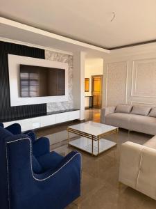 a living room with two couches and a tv at MAI instahomes in Lilongwe