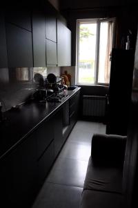 a kitchen with black cabinets and a window and a couch at Tsikhisdziri House 3 in Ts'ikhisdziri +10 photos