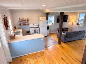 a kitchen and living room with a couch and a stove at Ocean Pines seaside cottage in Shelburne