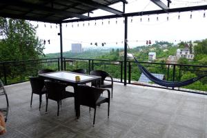a table and chairs on a balcony with a hammock at Tsikhisdziri House 3 in Ts'ikhisdziri