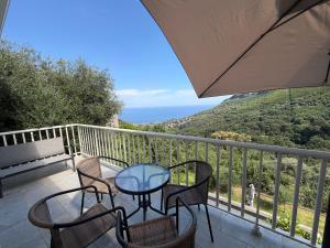 a patio with a table and chairs on a balcony at Charmant appartement sur les hauteurs d'Erbalunga in Brando