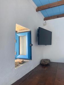 a room with a mirror and a tv on a wall at John's View in Serifos Chora