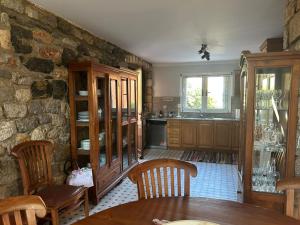 a kitchen with a table and a stone wall at Villa To Petrino in Vathís
