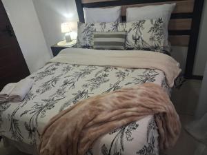 a bedroom with a bed with a blanket on it at Trendy Tranquility in Secunda