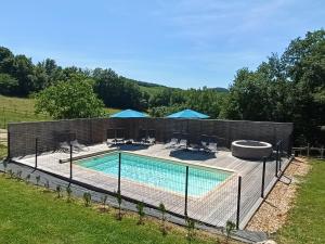 a swimming pool with a fence around it at Les roulottes de Joséphine in Veyrines-de-Domme