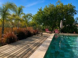 a swimming pool with two chairs and an umbrella at Finca Altozano - Private pool in Valle de Abdalagís