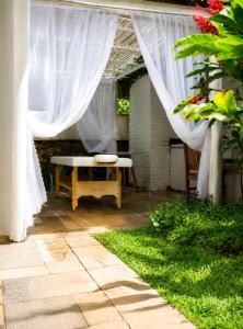 a patio with a white canopy and a bench at Savay Hotel Boutique - Guarujá in Guarujá +77 photos