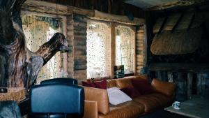 a living room with a couch and two windows at Finstonia Guesthouse in Vääna-Jõesuu