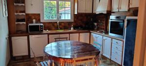 a kitchen with a table in the middle of it at Maison au bord de dune et océan in Labenne