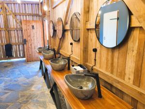 a row of sinks in a room with wooden walls at Resort Oblík - Luxusní stanové městečko in Raná