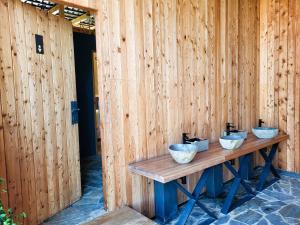 three bowls on a table in a wooden wall at Resort Oblík - Luxusní stanové městečko in Raná