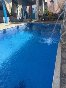 a pool with blue water in a hotel at Studio L'Artiste in Tozeur