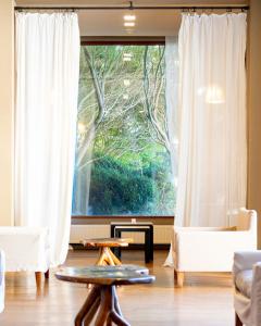 a living room with a large window with white curtains at Hotel Patagonico in Puerto Varas